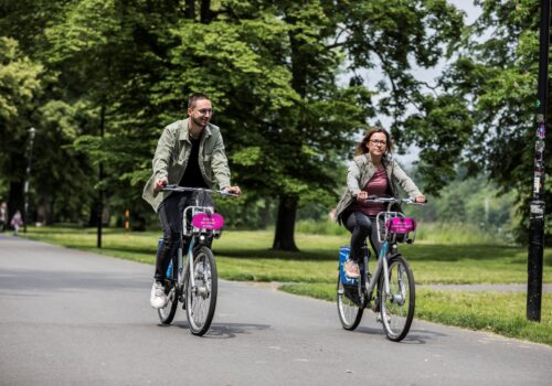 Dva cyklisté na kole - bikesharing