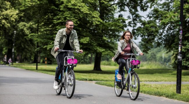 Dva cyklisté na kole - bikesharing